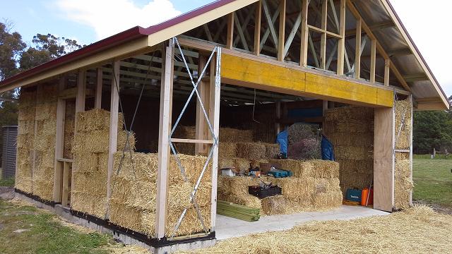 Strawbale+house+stacking+bales.jpg